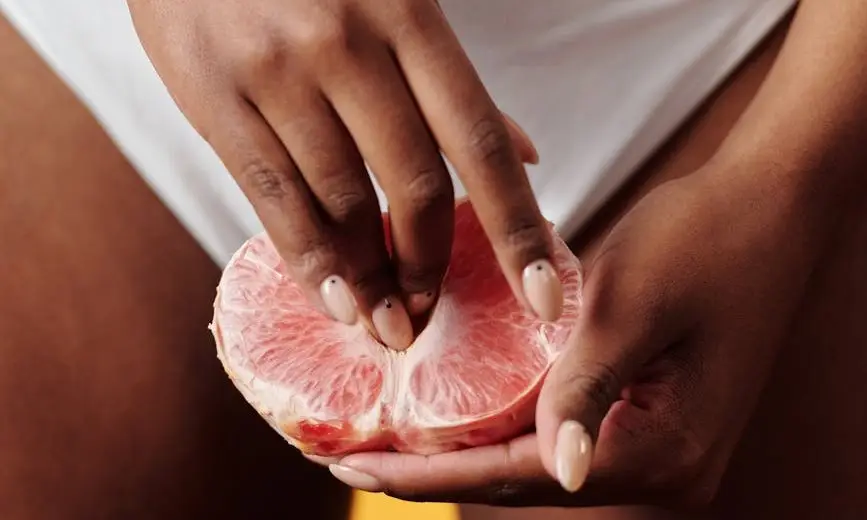 a woman holding a grapefruit
