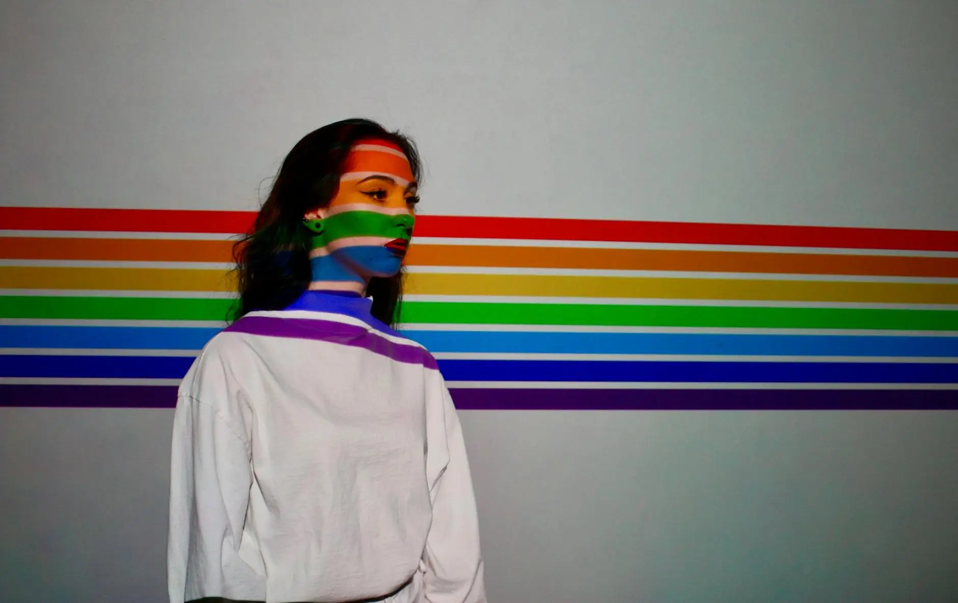 a woman in a sweater with a rainbow background